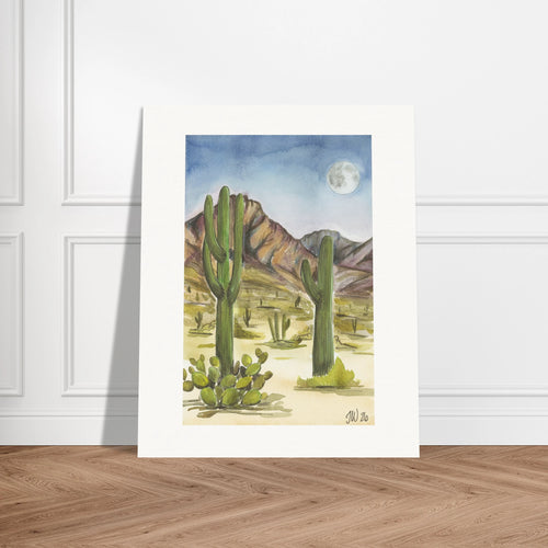 Fine art print by Houston based artist Jenny Wagner, Desert Moon. This watercolor print depicts a desert scene with saguaro cacti and a full moon in the background. Print shown leaning against a neutral wall