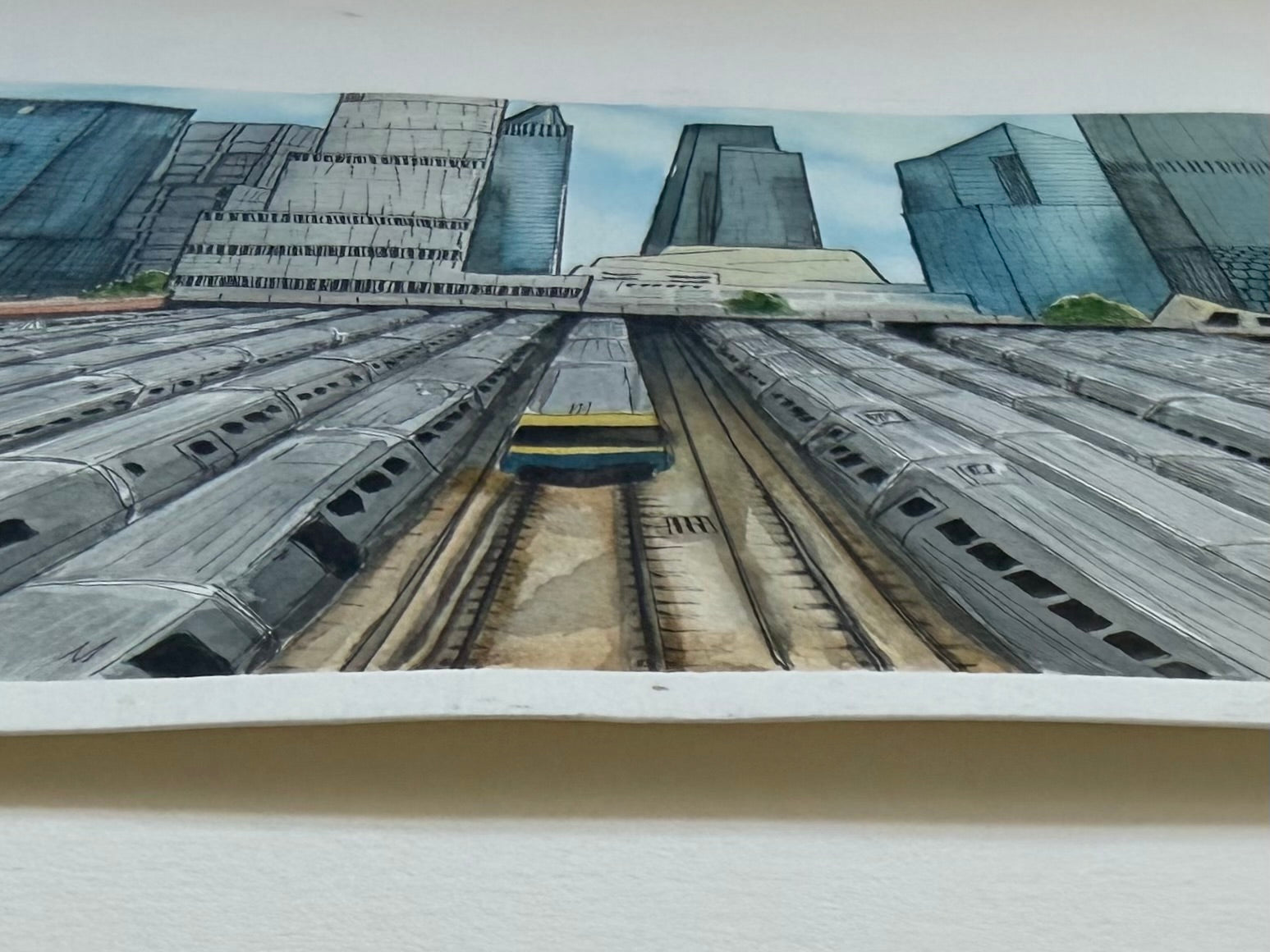 side view of paper quality of a Jenny Wagner Studio original watercolor with trains and a cityscape