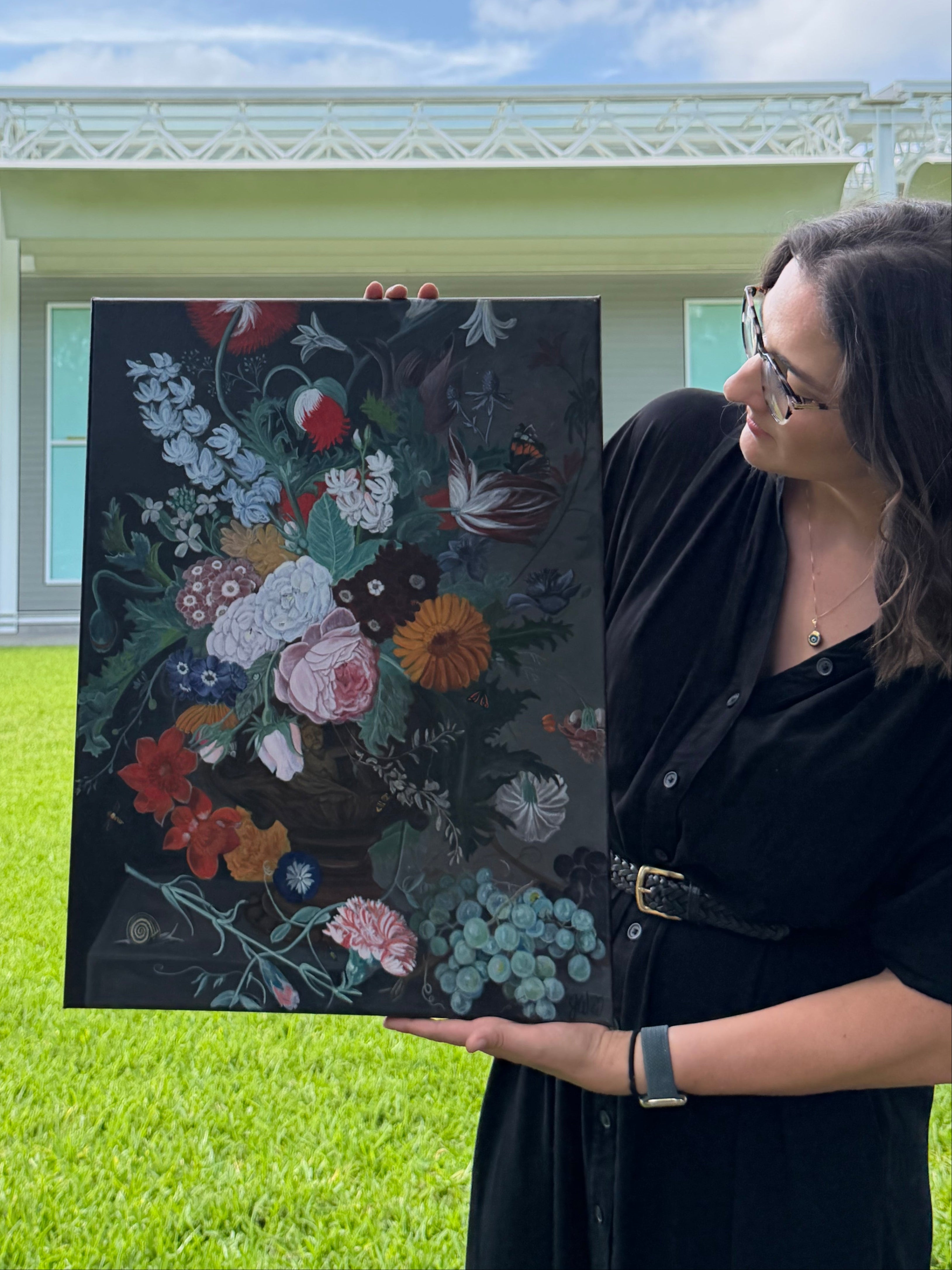 Texas artist, Jenny Wagner, shown holding her 18x24 acrylic painting based on a study of a classic Danish floral still life.