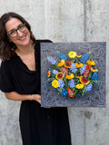 Texas artist Jenny Wagner revealing her original painting, "Wild at Heart" which depicts Texas wildflowers bursting from a bandana background.