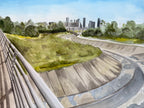 Watercolor painting of Houston's White Oak Bayou featuring lush green vegetation, a winding path, and downtown buildings