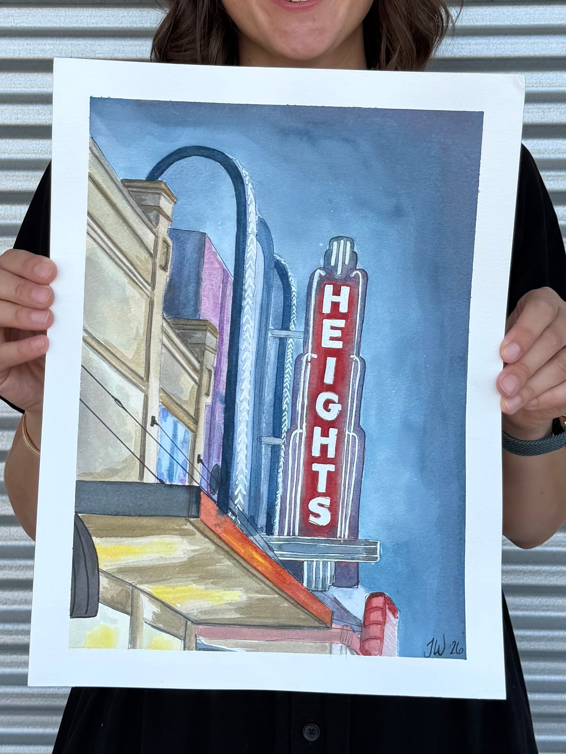 Jenny Wagner holding the original 12x16 watercolor painting of Houston's historic Heights Theater