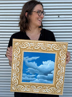 Bandana Sky, displayed by artist Jenny Wagner. This painting is a part of Wagner's ongoing Bandana series. A blue sky with billowing clouds is painted directly onto a yellow hand stretched bandana.