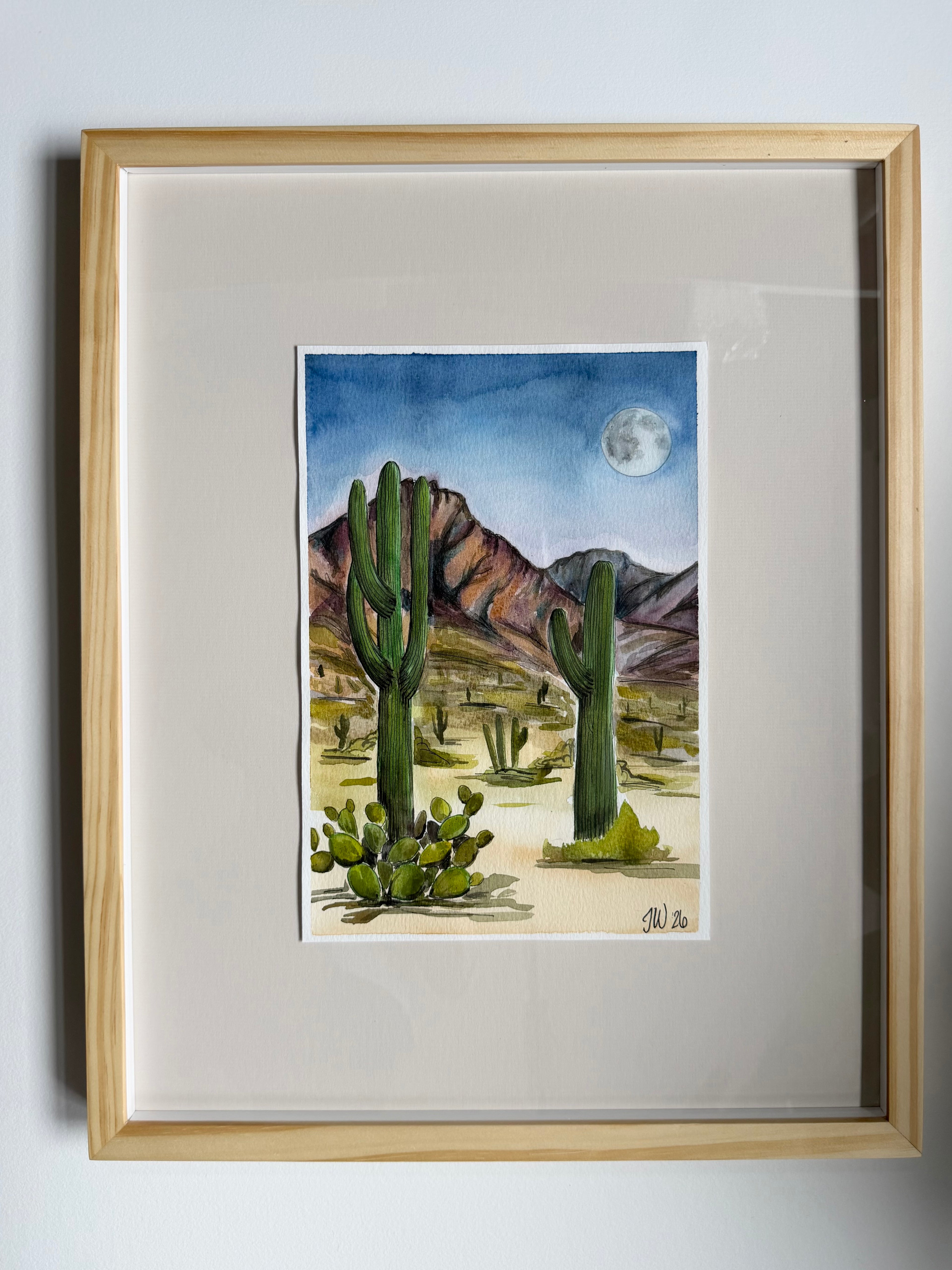 Original framed watercolor depicting a desert scene at nighttime with saguaro cacti and a full moon, by Texas artist Jenny Wagner